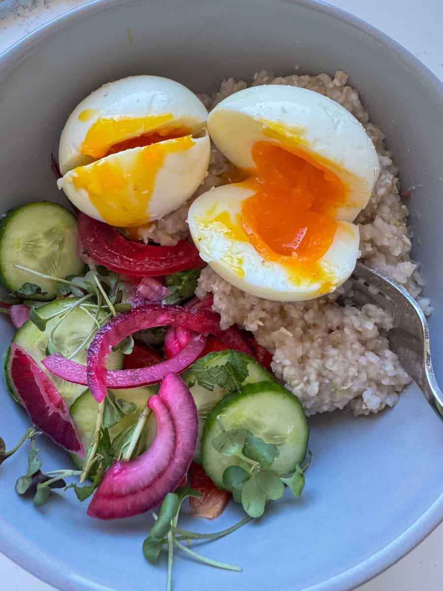Breakfast bowl with soft boiled eggs, marinated red onion and cucumber.