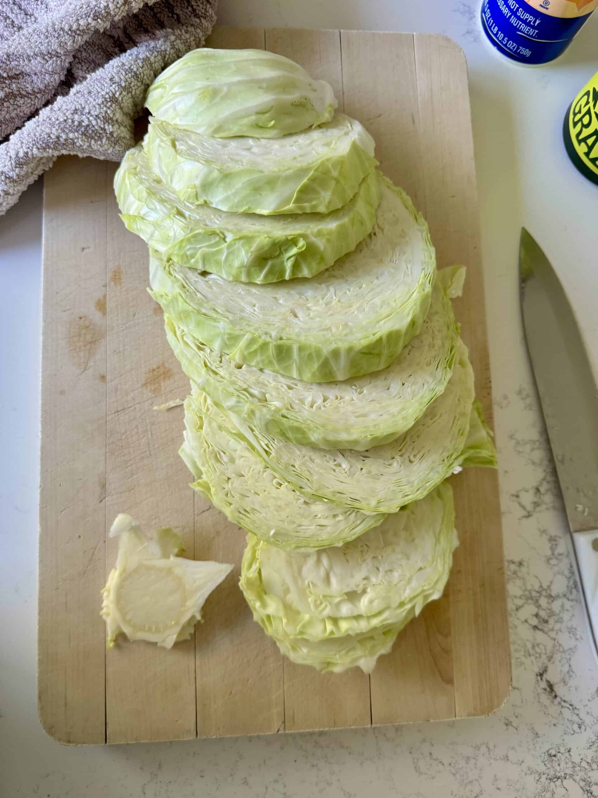 cutting board with cabbage sliced into slabs.
